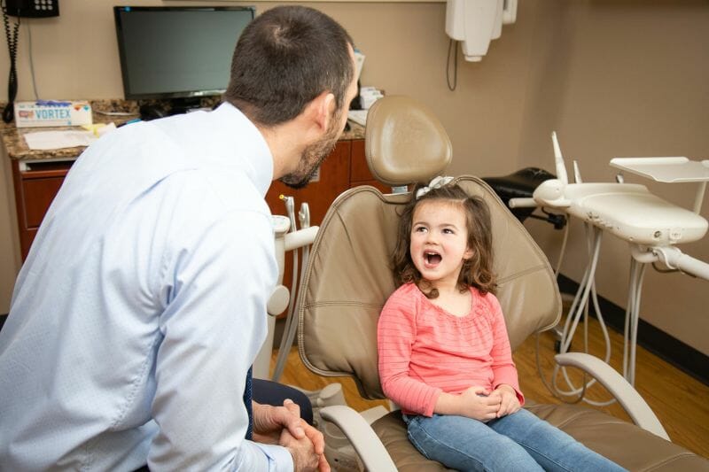 Dr. Green examining a young child's teeth for preventative care